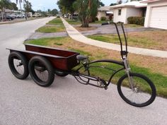 an old fashioned tricycle is parked on the side of the road in front of a house