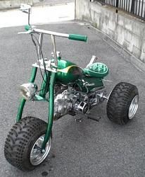 a small green motorcycle with big tires on the street