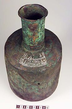 an old green vase with writing on it