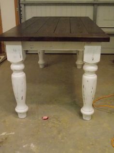 a white table with wooden top in a garage