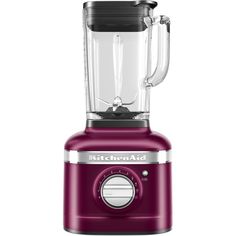 the kitchenaid blender is red and has a glass container on top of it