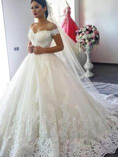 a woman in a wedding dress standing next to a mirror