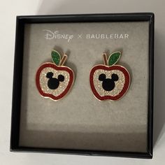 the disney x baublebar apple earrings are in a box