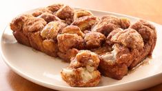 a white plate topped with cinnamon rolls on top of a wooden table