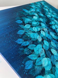 a painting with blue leaves painted on it