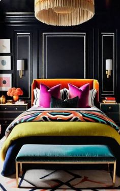 a bedroom with black walls, colorful bedding and an upholstered headboard