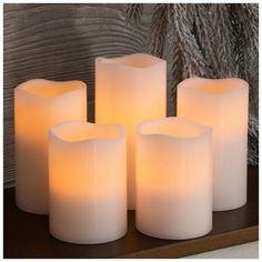 four white candles sitting on top of a table