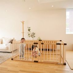 two children playing in a wooden playpen