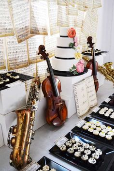 there is a cake with music notes on it and cupcakes in the foreground