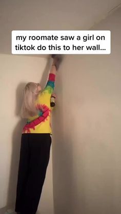 a person standing up against a wall with their arms in the air