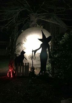 the silhouettes of two witches in front of a full moon