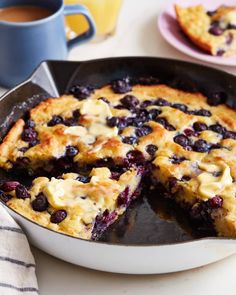 blueberry cobbler in a cast iron skillet with one slice cut from it