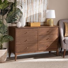 a living room with a chair and a dresser in front of a plant on the floor