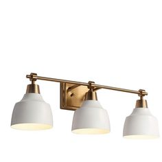 three light bathroom fixture with two white shades on the top and one gold finish,