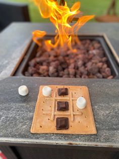 a waffle with marshmallows on it sitting in front of a fire