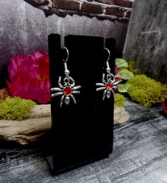 "These earrings features cool tiny spider charms with red rhinestones in them. They are on silver plated ear wires. Small but so cute! Earrings are 1 1/2\" total length and 3/4\" wide *Color may vary slightly due to camera flash or individual computer monitors Store policies: https://www.etsy.com/shop/eternalnightboutique#policies Back to the shop: https://www.etsy.com/shop/eternalnightboutique" Nickel-free Red Halloween Jewelry, Red Nickel-free Jewelry For Halloween, Red Novelty Jewelry For Halloween, Halloween Hypoallergenic Metal Jewelry, Hypoallergenic Jewelry For Halloween Party, Silver Themed Earrings For Halloween, Halloween Themed Silver Earrings, Themed Silver Earrings For Halloween, Themed Red Earrings