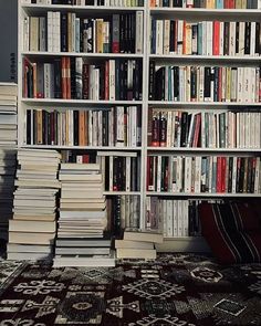 a large bookcase filled with lots of books on top of a carpeted floor