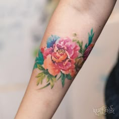 a woman's arm with a flower tattoo on it