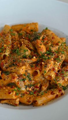 a white plate topped with pasta covered in sauce and parmesan sprinkles