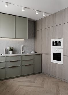 an empty kitchen with two ovens and some cupboards on the wall next to it