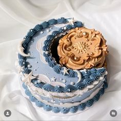 there is a blue and white cake with gold decorations on the top that looks like an ocean wave