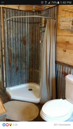 a bathroom with a shower, toilet and sink in it's own stall that is made out of corrugated