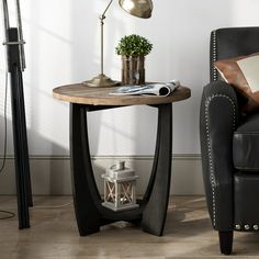 a living room with a chair, lamp and table on the floor in front of it