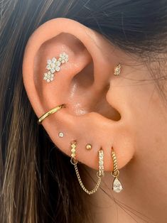 a woman's ear with three different piercings