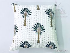 a white pillow with palm trees on it