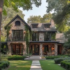 a large stone house surrounded by lush green trees