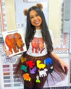 a woman holding up a book in front of her face and wearing a bear costume