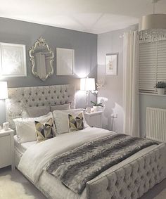 a bedroom with gray walls and white furniture