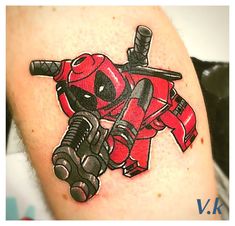 a deadpool tattoo on the arm of a person with a red and black motorcycle