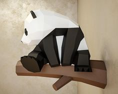 an origami panda bear sitting on top of a tree branch in a room