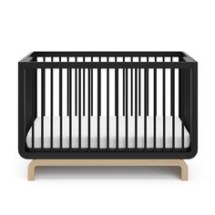 a black crib with white sheets on it