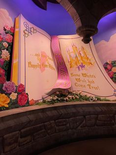 an open book is on display in front of a wall with flowers and the words happily married