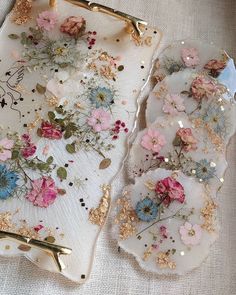 two trays with flowers on them sitting on a table