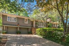 a house with trees and bushes in the front yard