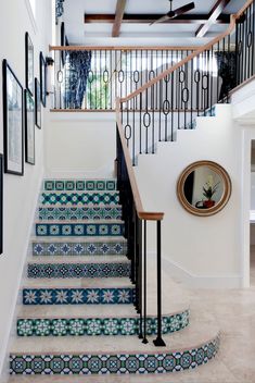 the stairs are decorated with blue and white tile designs, along with pictures on the wall