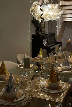 the table is set with silver and gold plates, napkins, and party hats