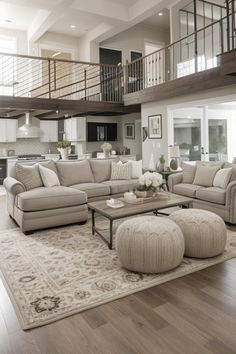 a living room filled with furniture on top of a hard wood floor covered in lots of windows