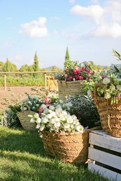 several baskets filled with flowers sitting on top of grass