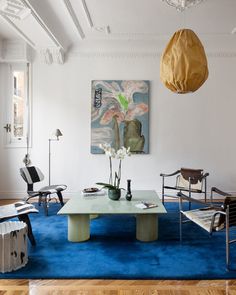 a living room filled with furniture and a blue rug on top of a hard wood floor