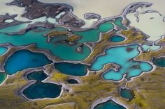 an aerial view of blue and green water in the desert, looking like it is floating on land