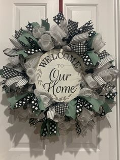 a welcome to our home wreath hanging on the front door