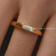 a close up of a person's hand with a gold ring on their finger