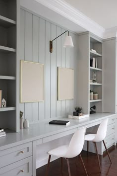 a white desk with two chairs next to it