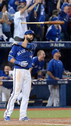 a baseball player holding a bat while standing on top of a field in front of a crowd