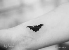 a small bat tattoo on the wrist