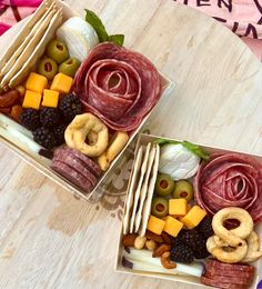 two boxes filled with different types of food on top of a wooden table next to each other